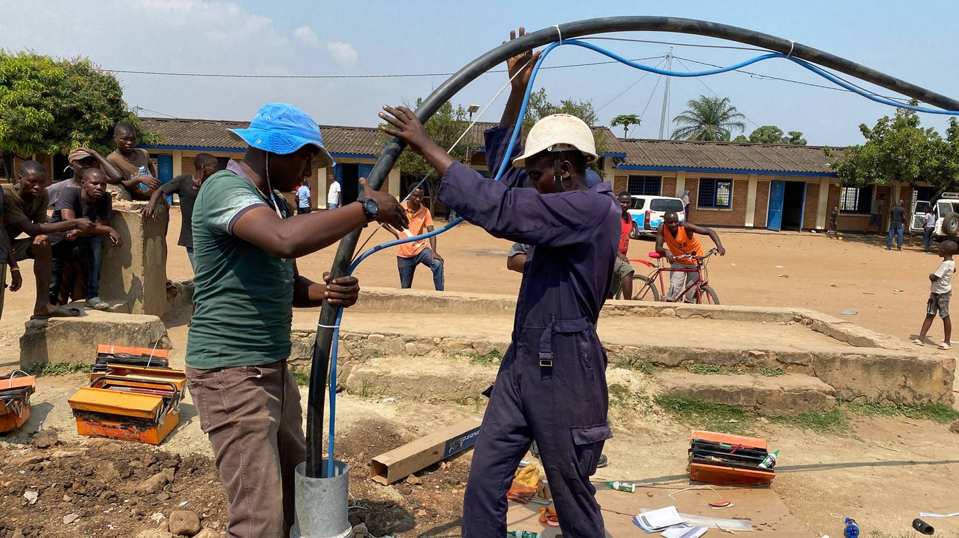 Descente d'une pompe immerg&eacute;e Grundfos dans un forage villageois au Burundi